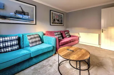 a living room with a couch and a table at Cosy 4 Bedroom Home In Glasgow City - Free Parking in Glasgow
