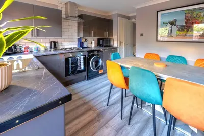 a kitchen with a long table and chairs at Cosy 4 Bedroom Home In Glasgow City - Free Parking in Glasgow