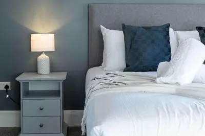a bedroom with a bed and a nightstand with a lamp at The Oliver in Ayr
