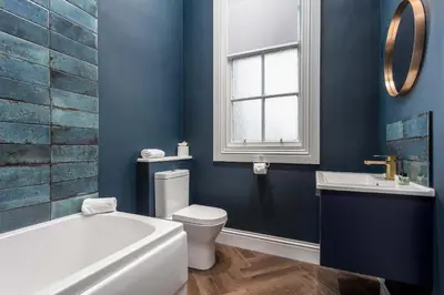 a bathroom with a tub and a toilet and a sink at The Oliver in Ayr
