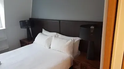 a bedroom with a bed with white sheets and pillows at CS Exclusive Apartments of Princess Street West End in Edinburgh