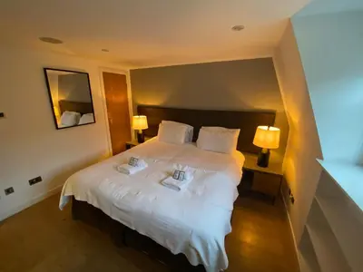 a bedroom with a large white bed with two lamps at CS Exclusive Apartments of Princess Street West End in Edinburgh