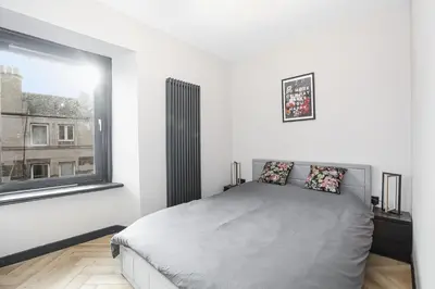 a white bedroom with a bed and a window at 1 Bedroom Gorgie Sleeps 4 Easy City Access in Edinburgh