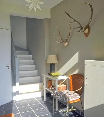 a room with a staircase with a chair and a desk at Black Barony Home Farm Cottage in Eddleston