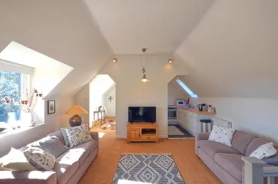 a living room with two couches and a tv at Black Barony Home Farm Cottage in Eddleston