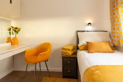 a bedroom with a bed and a desk and a chair at Tranquil Coastal Getaway Home in Saint Davids