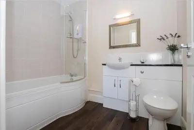a white bathroom with a toilet and a sink at Am Tighndhuin in Killin