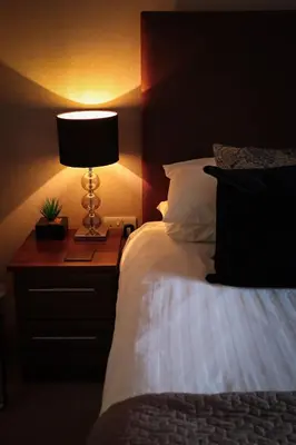 a bedroom with a bed and a lamp on a night stand at Am Tighndhuin in Killin