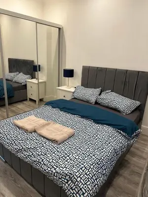 a bedroom with a large bed with a mirror at Cosy Flat in Glasgow