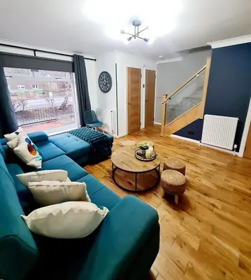 a living room with a blue couch and a table at Bright 3BR walking distance to town - FREE parking in Glasgow