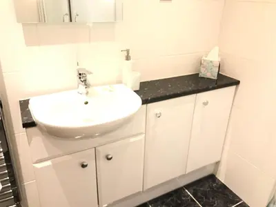 a white bathroom with a sink and a mirror at Castlecroft Bed and Breakfast in Stirling