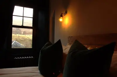 a bedroom with a bed with pillows and a window at Suie Hunting Lodge in Killin