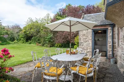 a table and chairs with an umbrella on a patio at 4 Bed in Cardross oc-t30303 in Cardross
