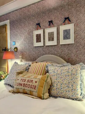 a bedroom with a bed with pillows and pictures on the wall at Clover Neuk - Hot Tub - Coorie Doon Stays in Fairlie