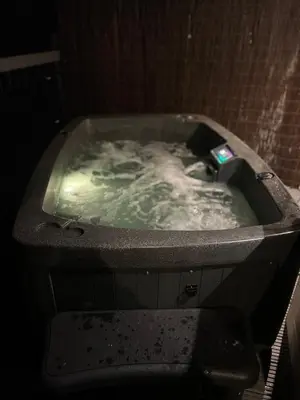 a bath tub filled with water in a bathroom at Clover Neuk - Hot Tub - Coorie Doon Stays in Fairlie