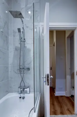 a bathroom with a shower and a tub with a sink at The Fullarton - Coorie Doon Stays in Troon
