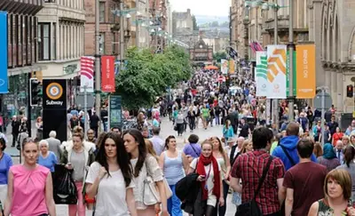 a crowd of people walking down a busy city street at Douglas Apartment - Trains to Edin & Glasgow - Private Parking in Airdrie