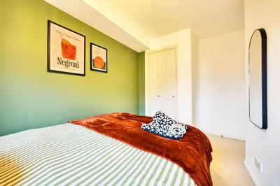 a bedroom with green walls and a bed with a blanket at 2BR Flat Central Location with Free Parking in Glasgow