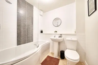 a white bathroom with a toilet and a tub and a sink at 2BR Flat Central Location with Free Parking in Glasgow