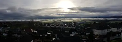 a view of a city with the sun poking through the clouds at The Tower Gastro Pub & Apartments in Crieff
