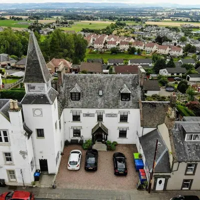 an aerial view of a large white house with cars parked at The Tower Gastro Pub & Apartments in Crieff