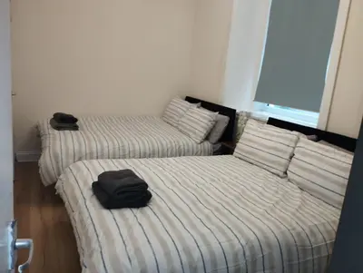 two beds in a room with two black towels on them at Flat in Central Edinburgh New Town , Lothian Road Heart of Edinburgh Flat Sleeps 4 in Edinburgh