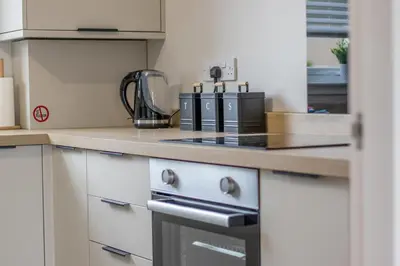 a kitchen with a stove top oven next to a counter at Westlea House in Airdrie
