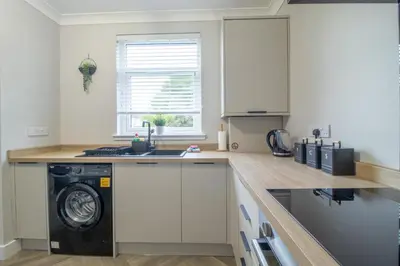 a kitchen with a washer and a washing machine at Westlea House in Airdrie