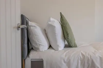 a group of pillows sitting on top of a bed at Westlea House in Airdrie