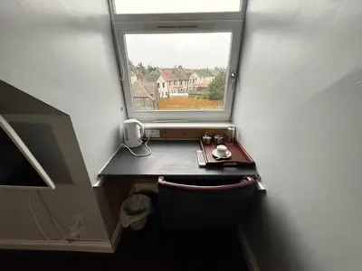 a small room with a desk and a window at Gothenburg Hotel in Rosyth