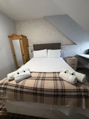 a bedroom with a bed with two towels on it at Gothenburg Hotel in Rosyth