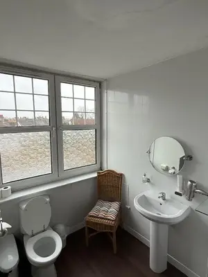 a bathroom with a toilet and a sink and a mirror at Gothenburg Hotel in Rosyth