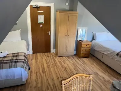 a attic bedroom with two beds and a wooden floor at Gothenburg Hotel in Rosyth
