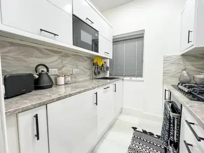 a kitchen with white cabinets and a counter top at Stylish Modern Glasgow Home with Excellent Value in Glasgow