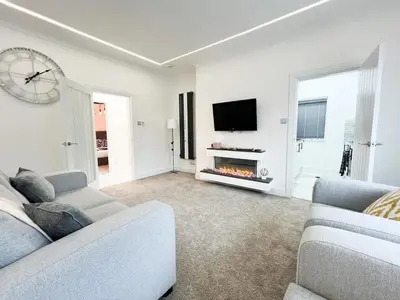 a living room with two couches and a tv at Stylish Modern Glasgow Home with Excellent Value in Glasgow