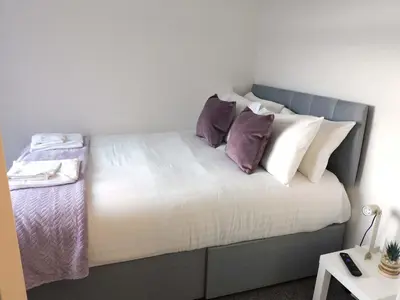 a bed with pillows on it in a room at 4 Bedroom Newly Refurbished Home in East Kilbride in East Kilbride