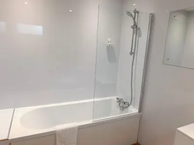a white bathroom with a shower and a tub at 4 Bedroom Newly Refurbished Home in East Kilbride in East Kilbride