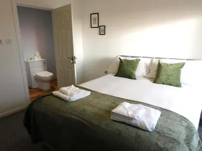 a bedroom with a bed with two towels on it at 4 Bedroom Newly Refurbished Home in East Kilbride in East Kilbride