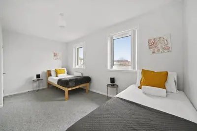 a white room with a bed and a chair at BridgeCity Hidden Gem in the heart of Falkirk Roughland house Stirlingshire in Carron