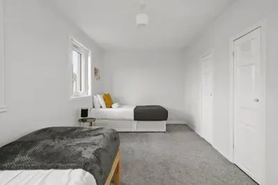 a white bedroom with a bed and a window at BridgeCity Hidden Gem in the heart of Falkirk Roughland house Stirlingshire in Carron