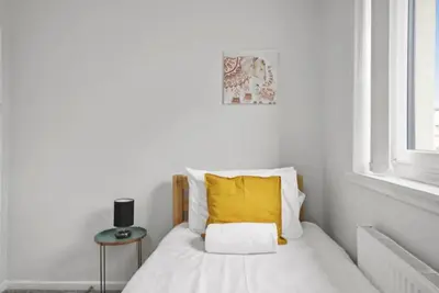 a white bedroom with a bed with a yellow pillow at BridgeCity Hidden Gem in the heart of Falkirk Roughland house Stirlingshire in Carron