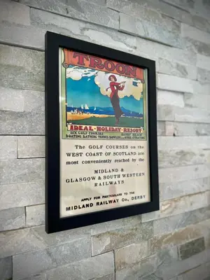 a sign on a brick wall with a movie poster at Kennedy Cottage by Troon beach in Troon