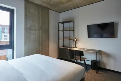 a bedroom with a bed and a desk and a tv at The Social Hub Glasgow Extended Stay in Glasgow