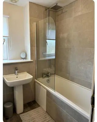 a bathroom with a sink and a tub and a shower at Modern staycation Apartment in Caldercruix