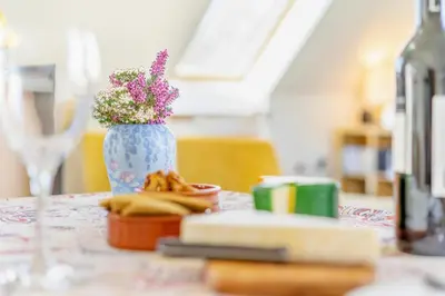 a table with a vase of flowers and a bottle of wine at 1 Bed in Methven oc-v30533 in Methven