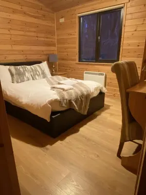 a bedroom with a bed and a desk and a window at Lomond Lodge Rowardennnan in Rowardennan