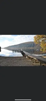 a lake with a dock in the middle of it at Lomond Lodge Rowardennnan in Rowardennan