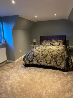 a bedroom with a bed and a blue wall at The Barn in Hawkhead