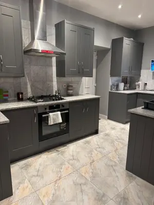 a kitchen with gray cabinets and a stove top oven at The Barn in Hawkhead