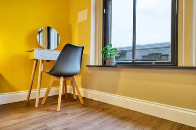 a chair sitting at a desk in a room with a window at Lovely Central Station 1 Bed Apartment A6 in Glasgow
